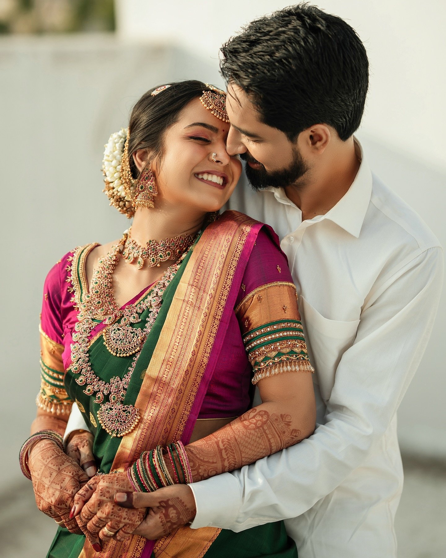 Bride and groom exchanging warm smiles with wedding garlands
