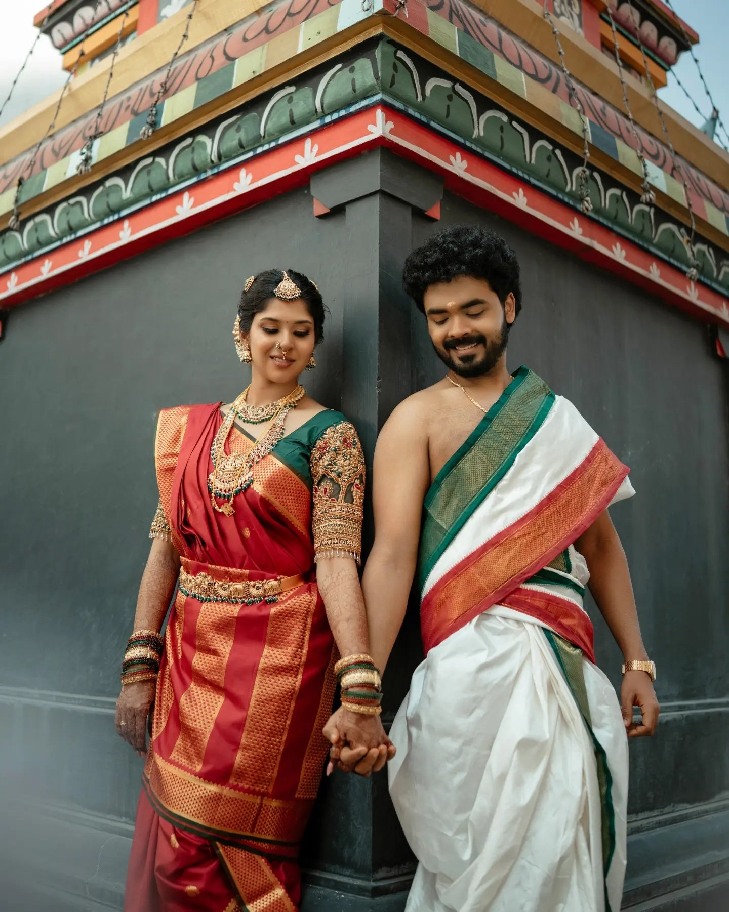 A couple in ceremonial attire walking together in classic monochrome